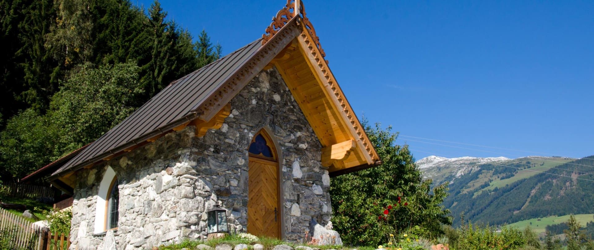 Die Christophoruskapelle am Kapellenweg mit traditioneller Steinarchitektur und einem kunstvollen Holzdach